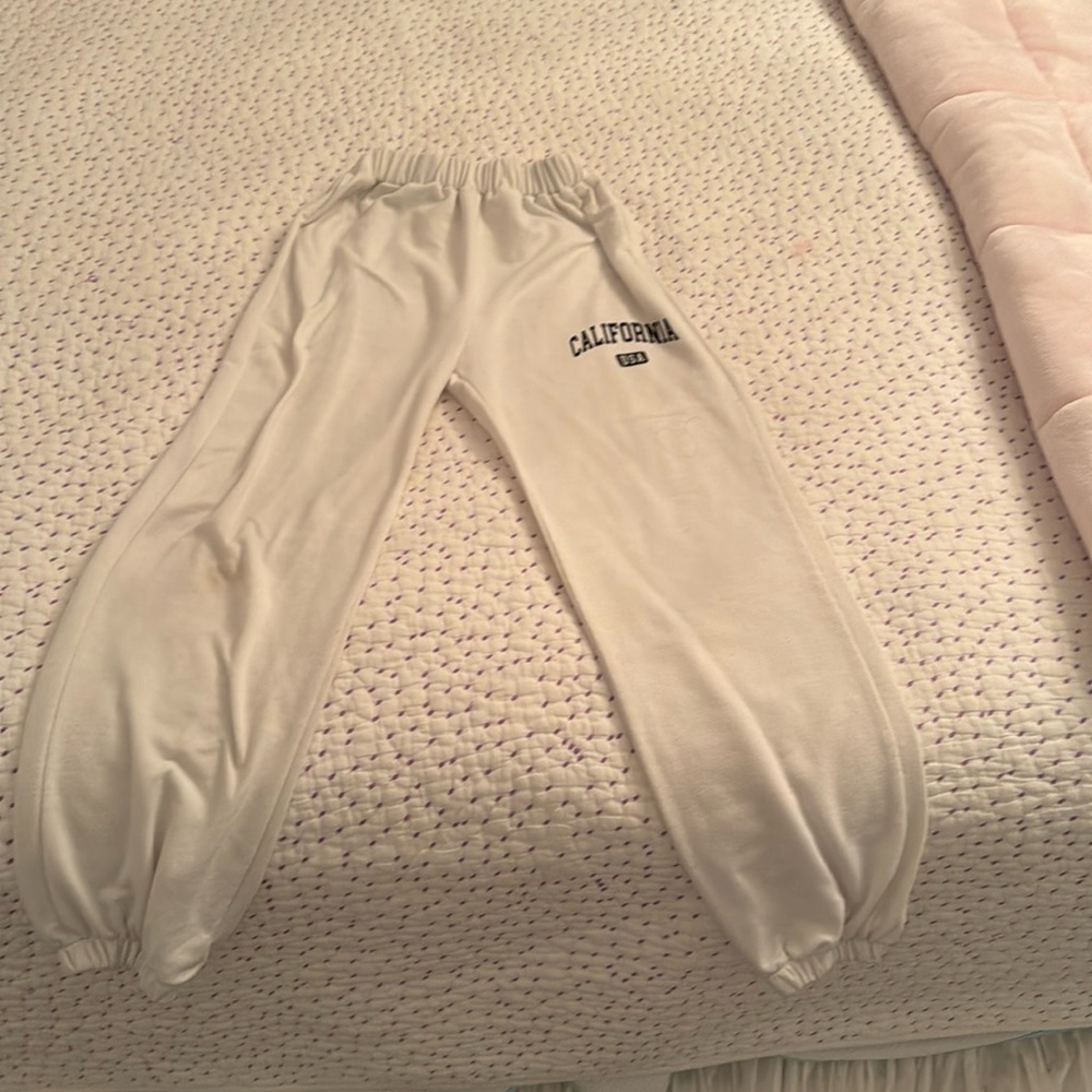White sweatpants that say California USA on them